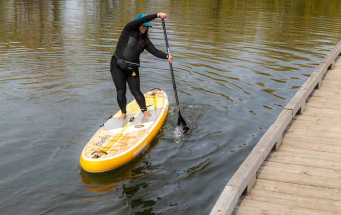 Woman demonstrating intermediate SUP techniques on a stand up paddleboard