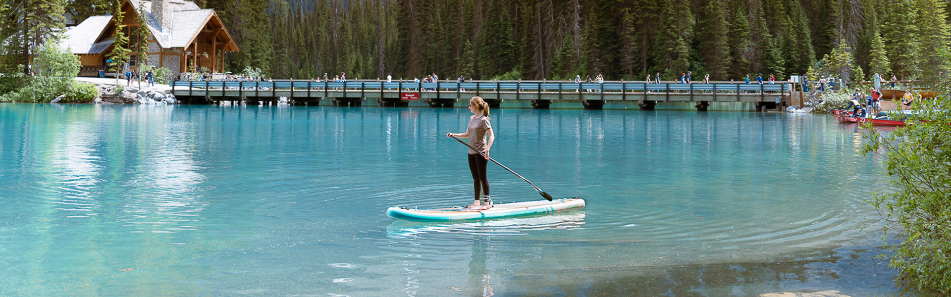 a woman paddling thurso paddle board at lake